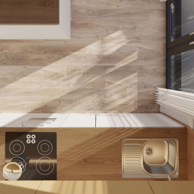 A modern kitchen scene with light wood cabinetry and backsplash, a black induction cooktop, and a stainless steel single-basin sink with a gold-toned drain basket. Sunlight casts diagonal shadows across the wood surfaces.

Torlys Rigidwood Firm Premier Dakota Luxury Vinyl, a wide plank, low sheen floor available at Alberta Hardwood Flooring.